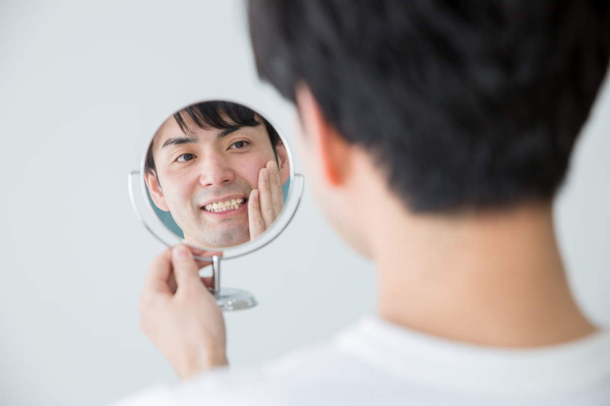 歯の噛み合わせのセルフチェックをしている男性