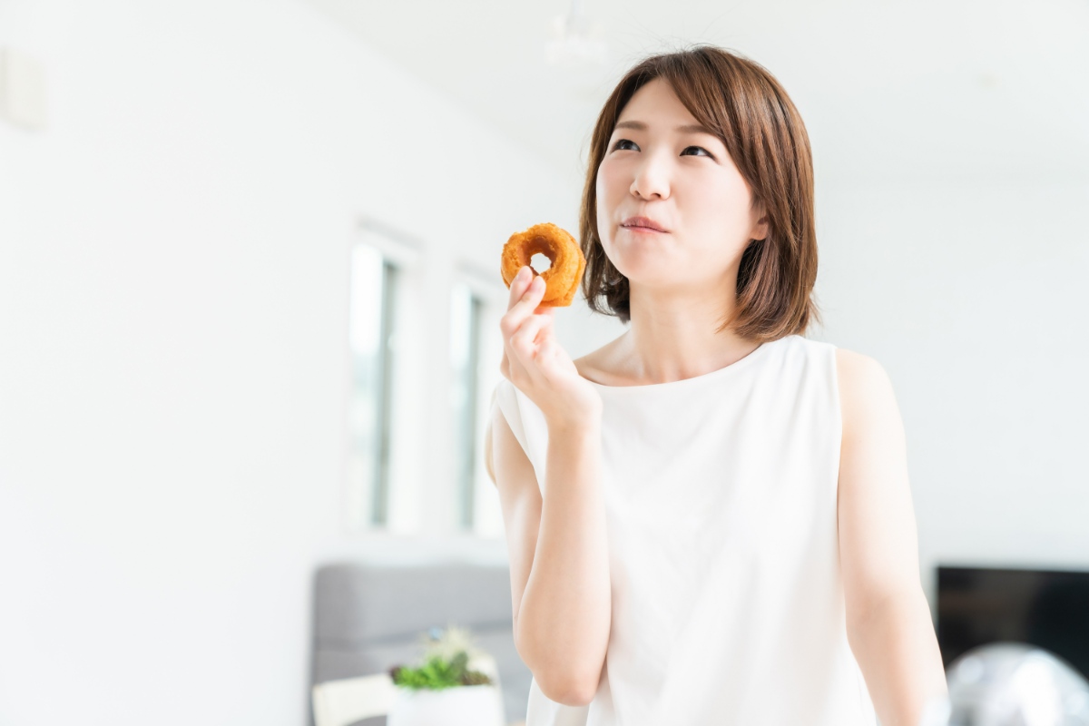 甘いドーナツを食べる女性