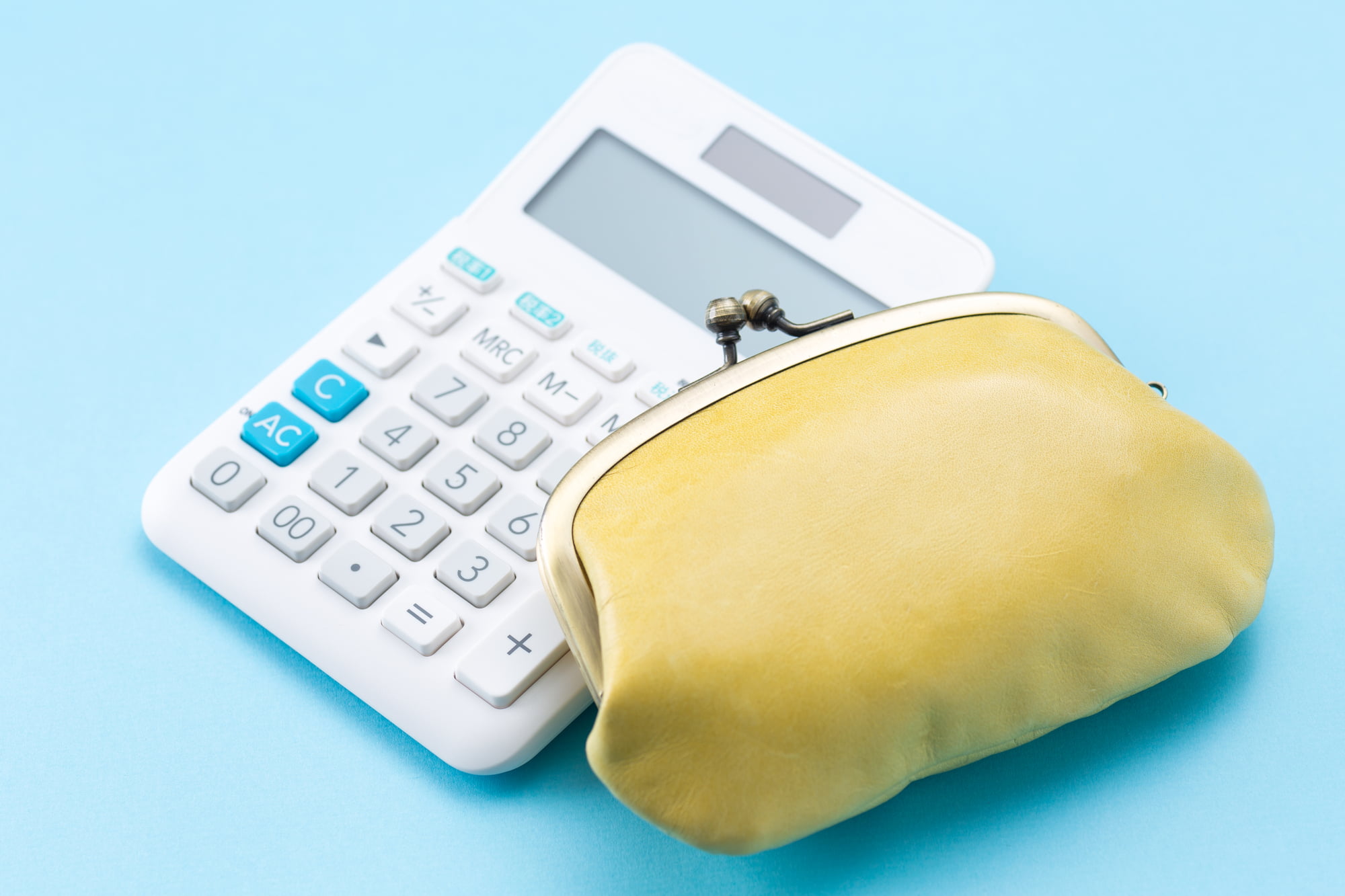 根管治療にかかる費用を示す計算機と黄色のがま口財布