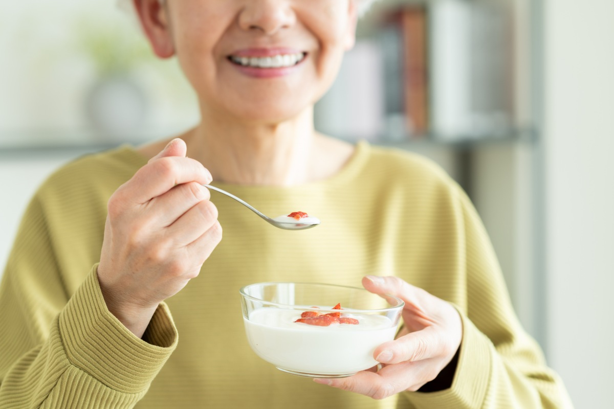 ヨーグルトを食べているシニア女性