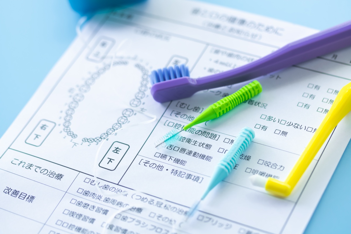歯ブラシなどの口腔ケア用品と定期歯科検診のカルテ