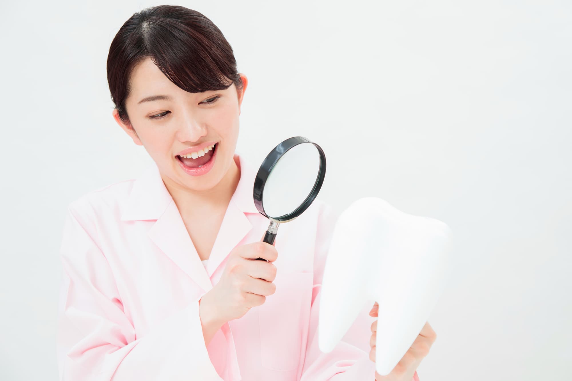 虫歯か着色かを見分ける歯科医師の女性