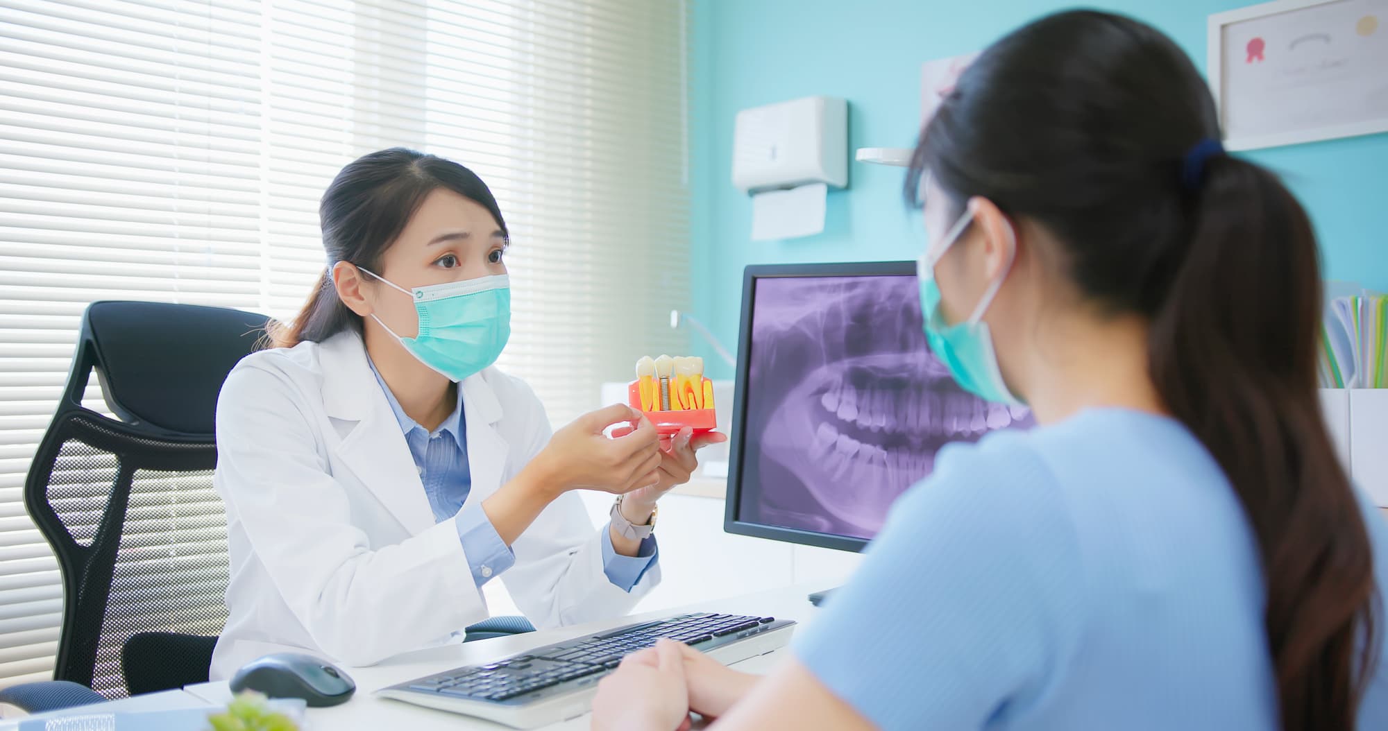 インプラント周囲炎の治療について説明する歯科医師と説明を聞く女性